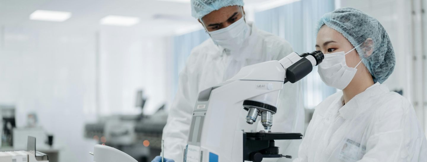 Biomedical scientists conducting research in a sterile lab environment.