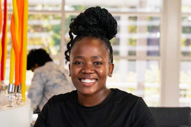 Smiling female student in a black top with a high bun hairstyle in classroom.