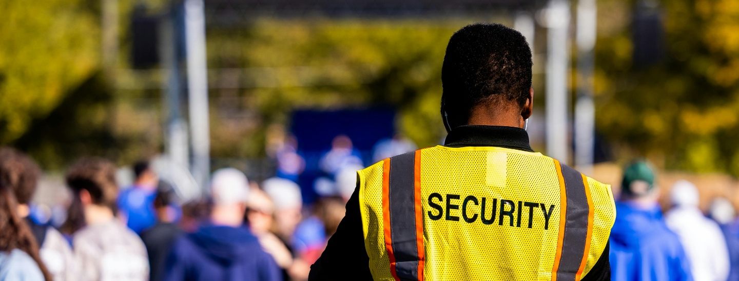 Professional security staff monitoring an outdoor public gathering to ensure attendee safety and crowd control.