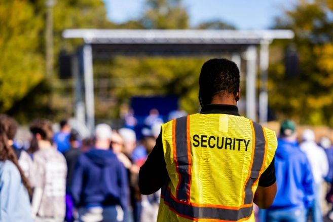 Professional security staff monitoring an outdoor public gathering to ensure attendee safety and crowd control.