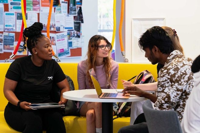 ECC college students engaged in a group study session in a colorful common area.