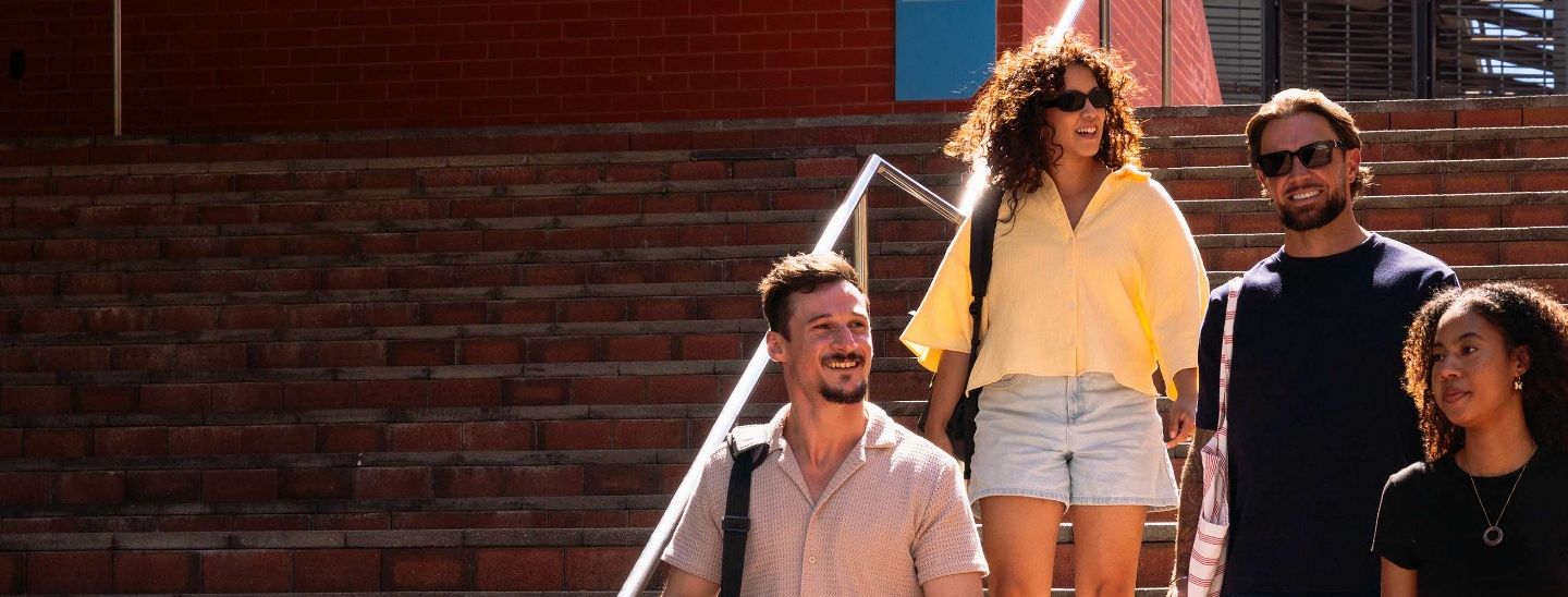 Students walking down outdoor stairs at ECU campus.