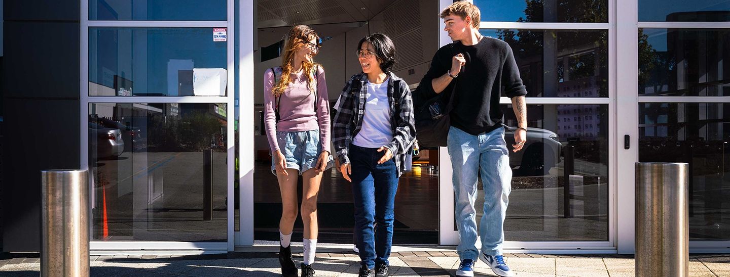 Students walking together outside a university building entrance.