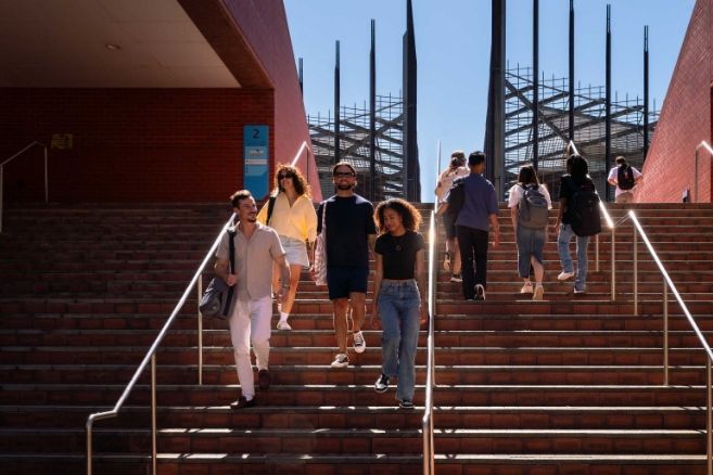 Students walking down outdoor stairs at ECU campus.