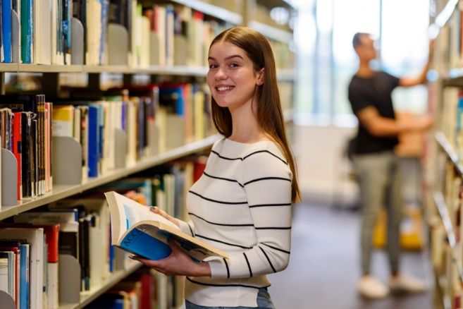 Female holding books in library