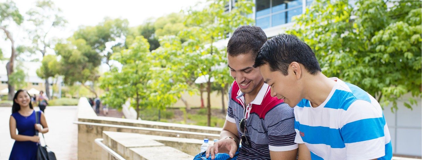 Male students looking at digital pad