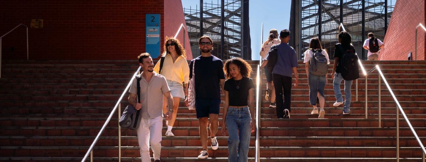 Group of students walking up and down outdoor brick stairs in college campus