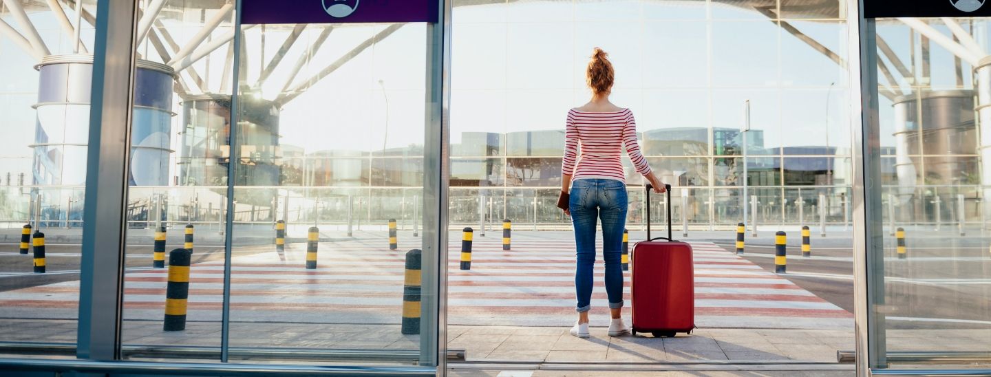 Off campus female pulling suitcase in airport