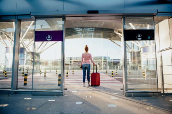 Off campus female pulling suitcase in airport