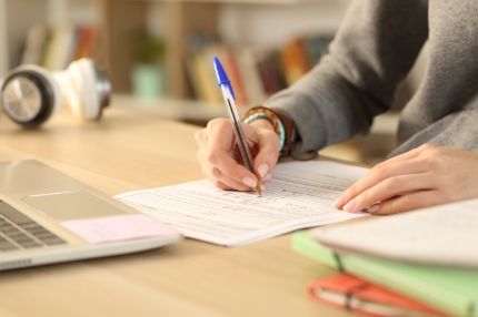 Off campus female writting on form