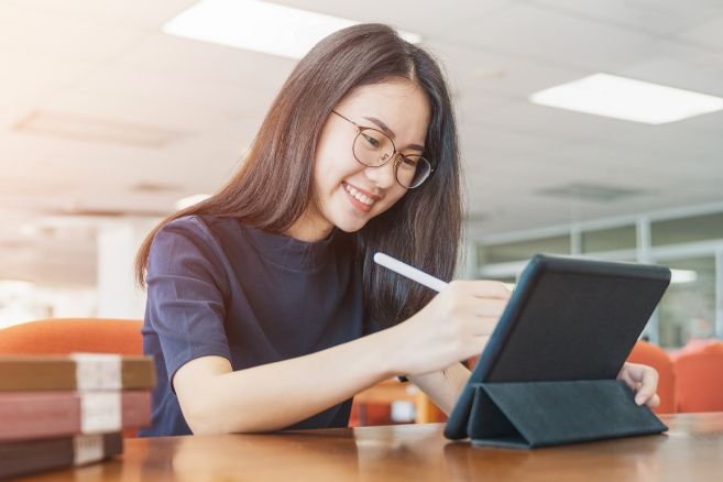 Off campus focused female student works on tablet