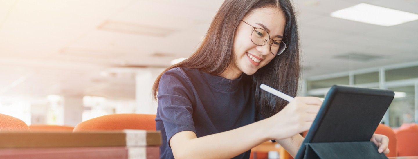 Off campus focused female student works on tablet