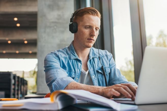 Off campus focused male student studys in library