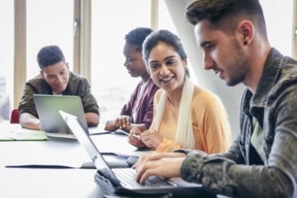 Off campus group looking at laptops