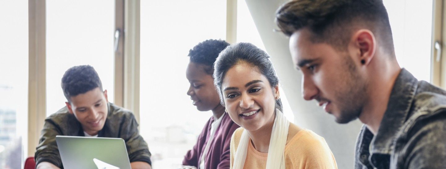 Off campus group looking at laptops