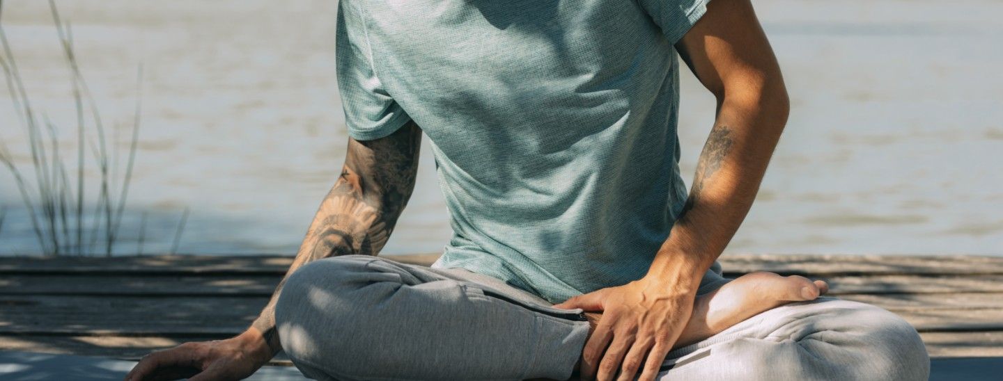 Off campus male crossing legs on matt