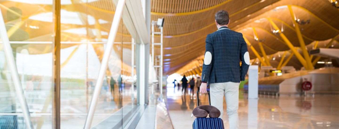 Off campus male pulling suitcase in airport