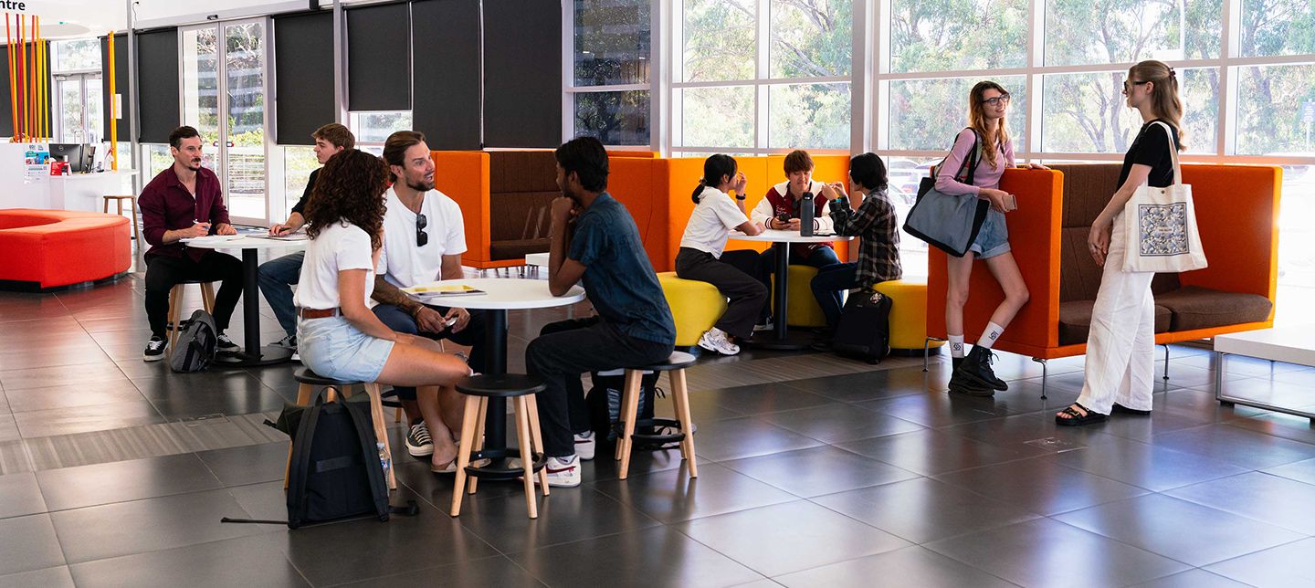 Group of students sitting on tables in college campus