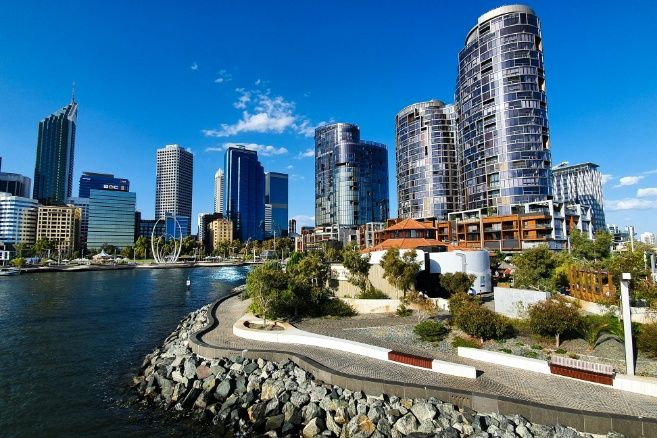 A wide-angle view of the Perth city skyline and Elizabeth Quay under a clear blue sky.