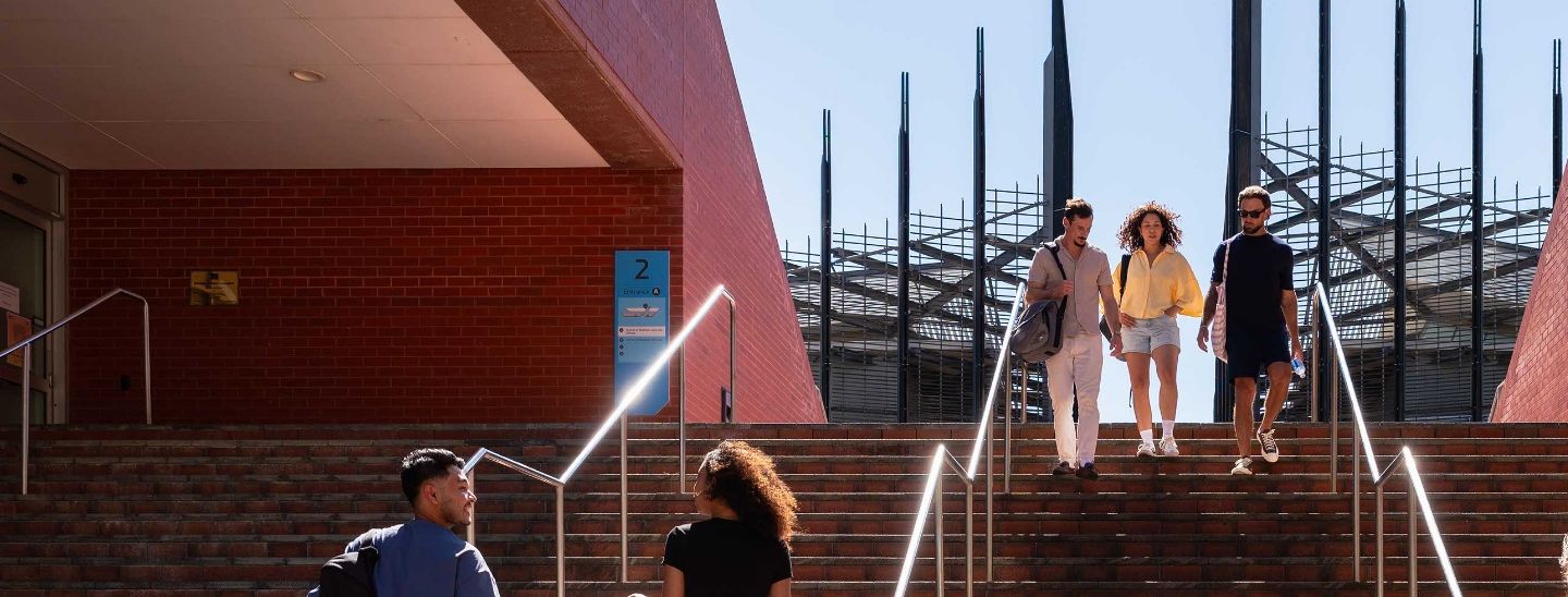 Students walking down outdoor stairs at ECU campus.